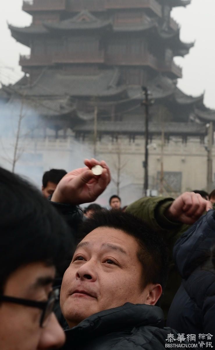 香客在武汉寺庙祈福扔硬币 工作人员戴头盔清理