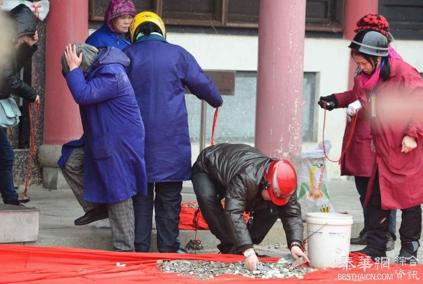 香客在武汉寺庙祈福扔硬币 工作人员戴头盔清理