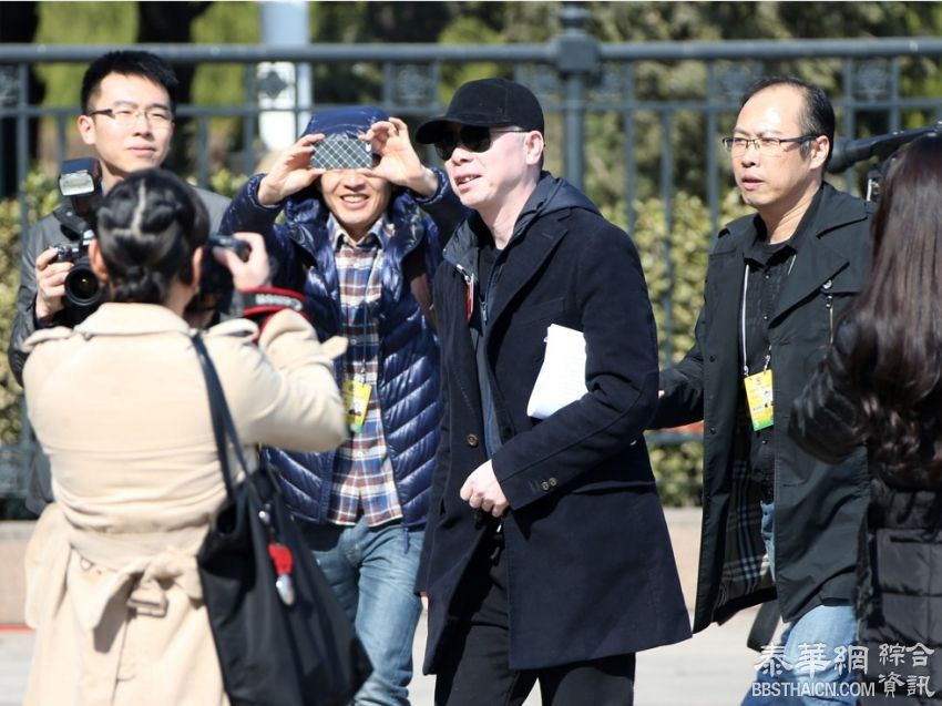 冯小刚参加两会 为躲记者钻警戒线